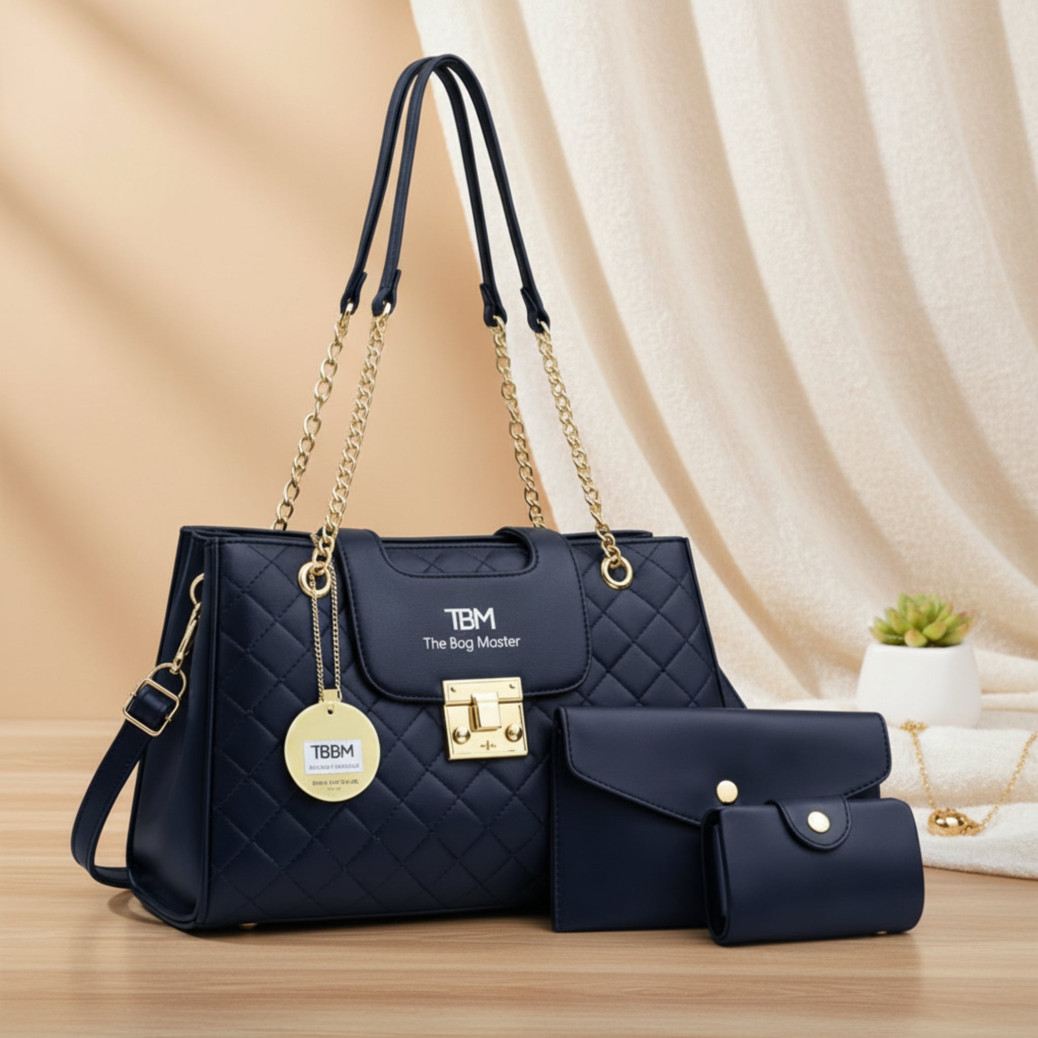 Black handbag with gold accents and matching wallet on a beige fabric background