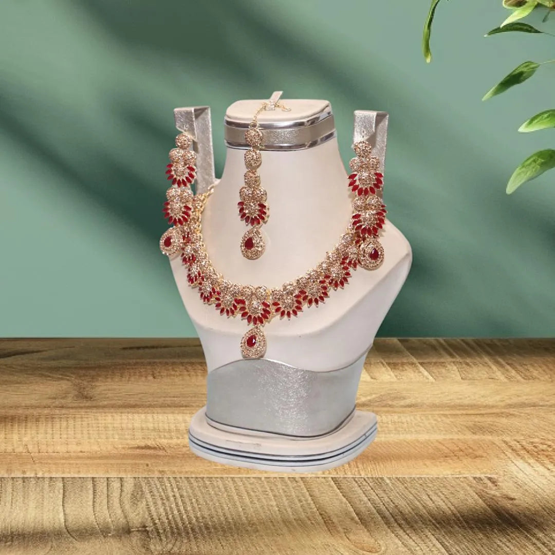 Jewelry set including necklace, earrings, and ring on a white mannequin bust with a green background.