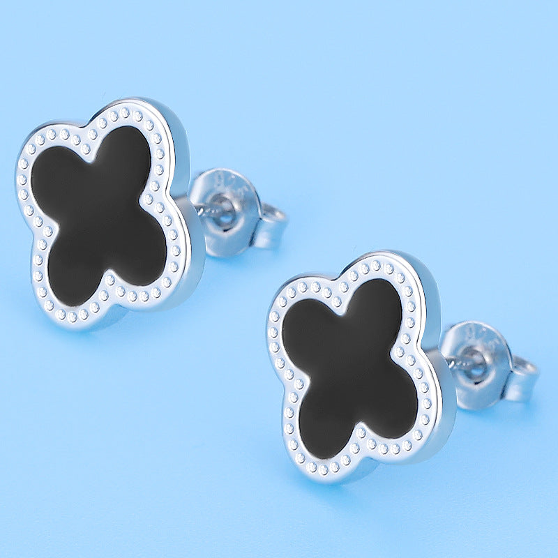 Butterfly-shaped earrings with black centers on a light blue background
