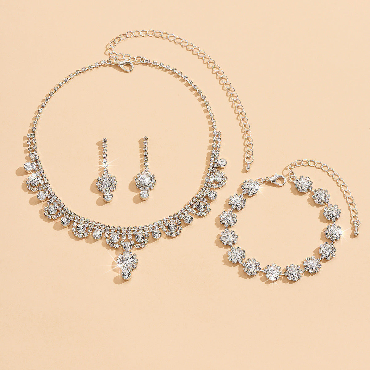 Jewelry set with necklace, earrings, and bracelet on a beige background
