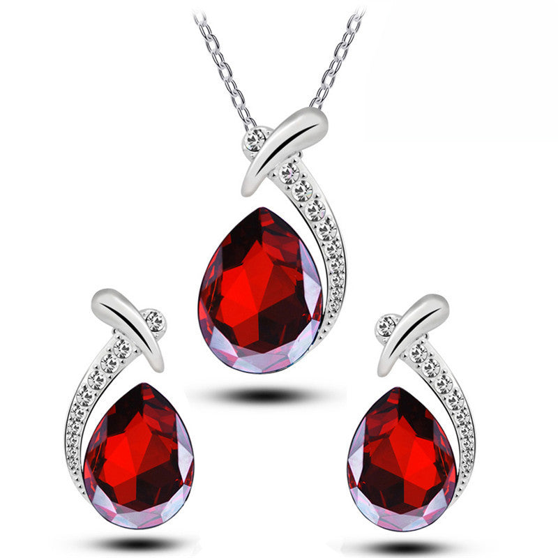 Jewelry set with red teardrop-shaped gemstones on a white background