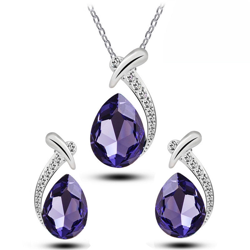 Jewelry set with purple teardrop-shaped gemstones and silver accents on a white background