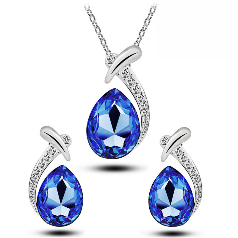Jewelry set with blue teardrop-shaped gemstones and silver accents on a white background