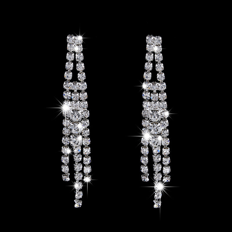 Pair of sparkling diamond-like earrings on a black background
